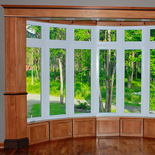 Habillage de bay-window avec panneaux et moulures en bois francs