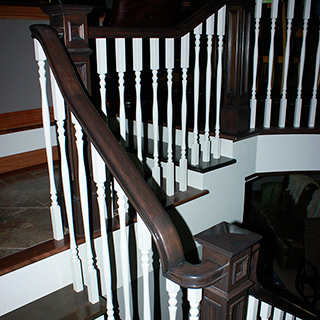 Rampe d'escalier en bois franc avec barreaux tournés et main courante travaillée