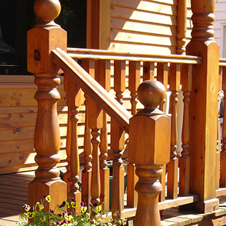 Galerie coloniale avec poteaux tournés et balustrades en bois naturel